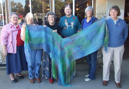 Llama Mama team holds finished shawl